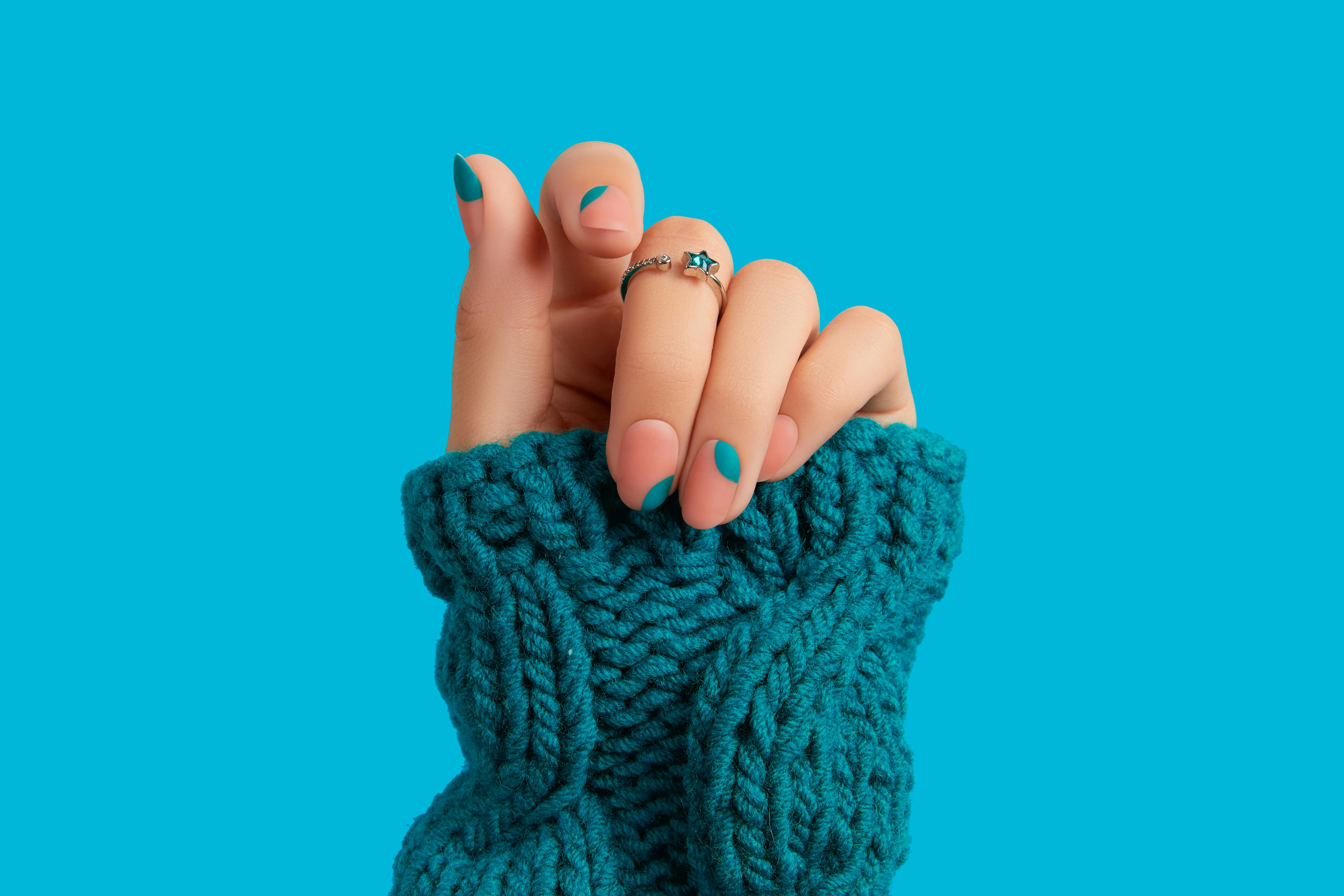 Woman's hand with blue manicure, a great option for Aquarius nail designs