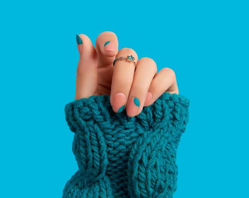 Woman's hand with blue manicure, a great option for Aquarius nail designs