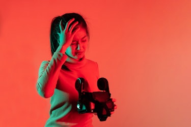 Asian Woman Hold VR Headset Suffer From Motion Sickness