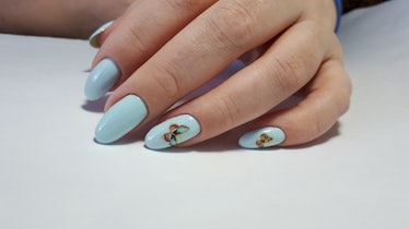 Hand with blue butterfly nail design, the Taylor Swift-themed manicure for fans of her debut era.