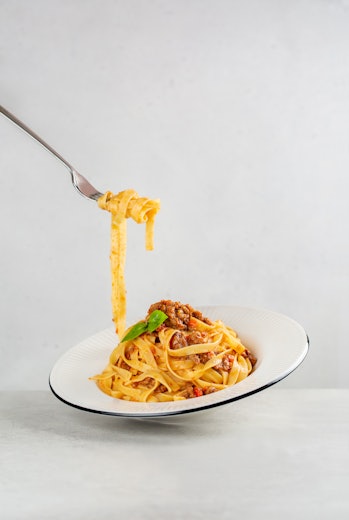 Egg pasta tagliatelle with bolognese sauce made from meat and tomato sauce.