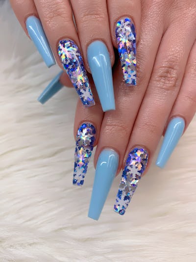 Manicure with snowflakes on your nails with colored gel polish on a coffins shaped nails.
