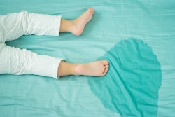 Kid's feet and pee on a mattress in an article about how to wash your mattress cover