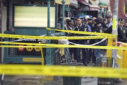 New York City Police Department personnel gather at the entrance to a subway stop in the Brooklyn bo...