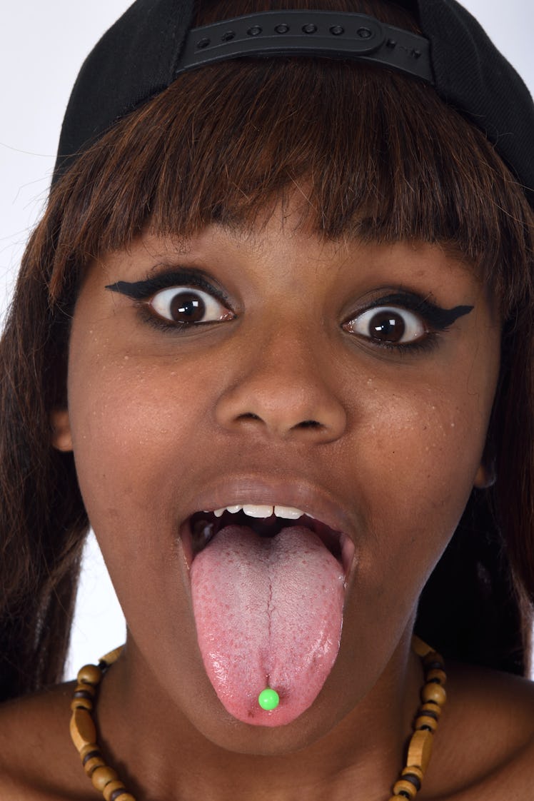 A woman with a neon green tongue piercing.