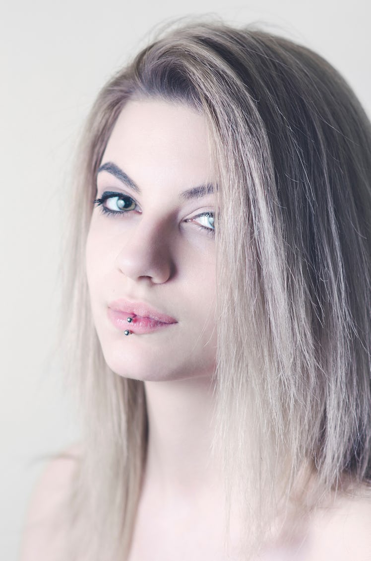 Model with a facial, labret piercing on her lip.