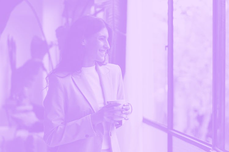 A college graduate holding a coffee cup at her job