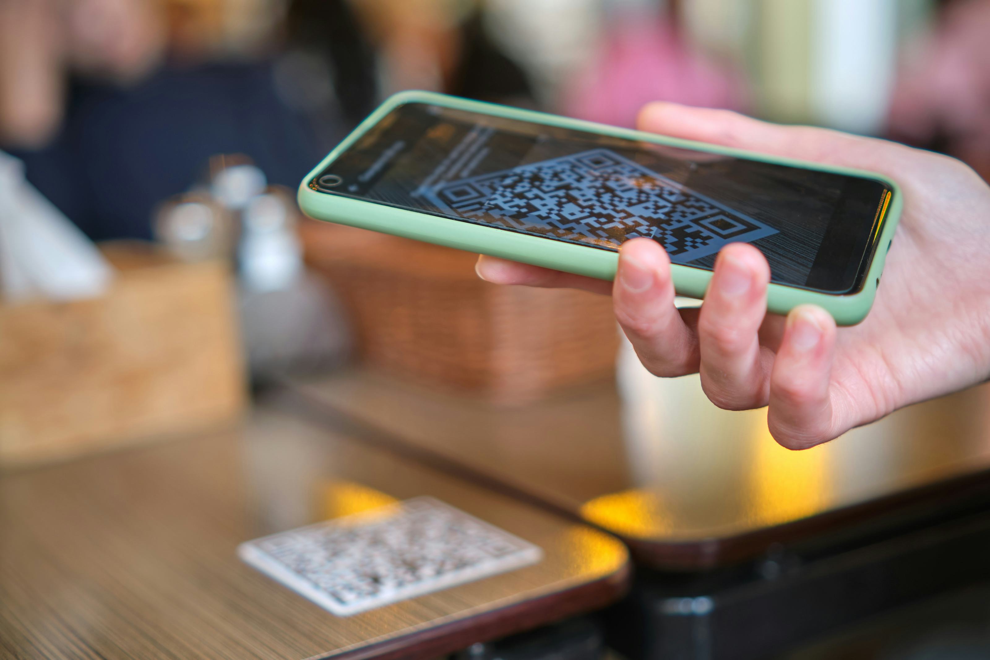 Closeup of guest hand ordering meal in restaurant while scanning qr code with mobile phone for onlin...