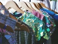 Brightly colored prom dresses, mermaid prom dresses, and sparkly prom dresses on a clothing rack