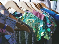 Brightly colored prom dresses, mermaid prom dresses, and sparkly prom dresses on a clothing rack