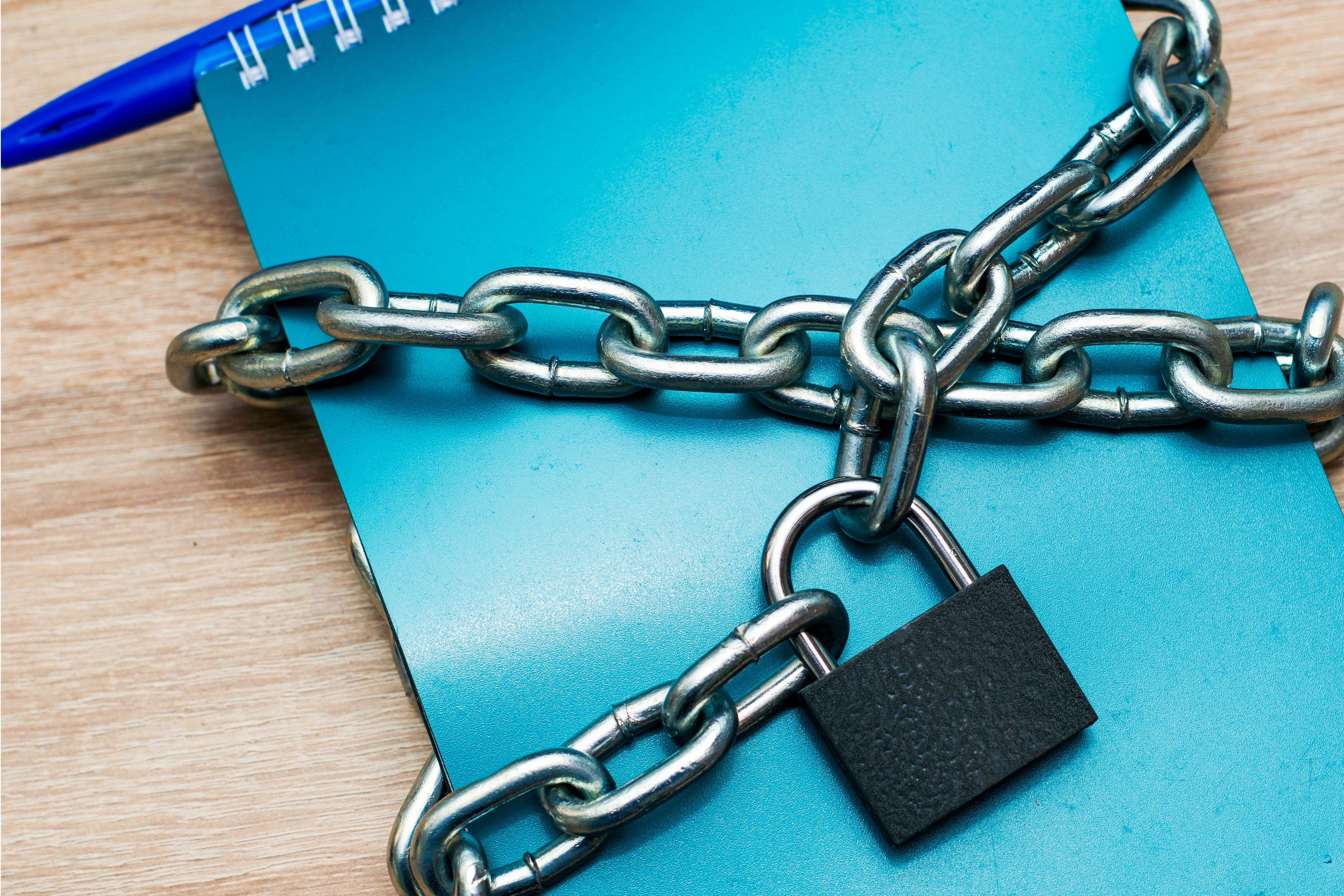 the notebook for writing is wrapped with an iron chain closed with a lock concept information protec...