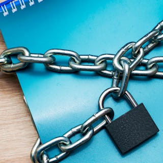 the notebook for writing is wrapped with an iron chain closed with a lock concept information protec...