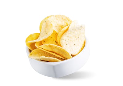 Yellow potato chips with salt and season on a white isolated background. toning. selective focus