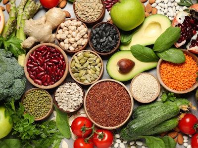 Different vegetables, seeds and fruits on grey table, flat lay. Healthy diet