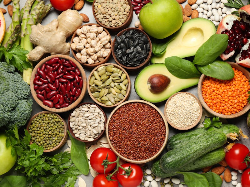 Different vegetables, seeds and fruits on grey table, flat lay. Healthy diet