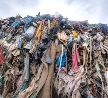 Unsellable imported second-hand clothes rotting in a dumpsite in Ghana's capital city. This dumpsite...