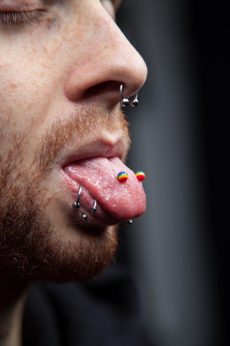 A model with a tongue, septum, and shark bite piercings.