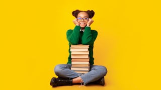 Teen sitting with a stack of books. All U.S. teens can now utilize the resources of the Brooklyn Pub...