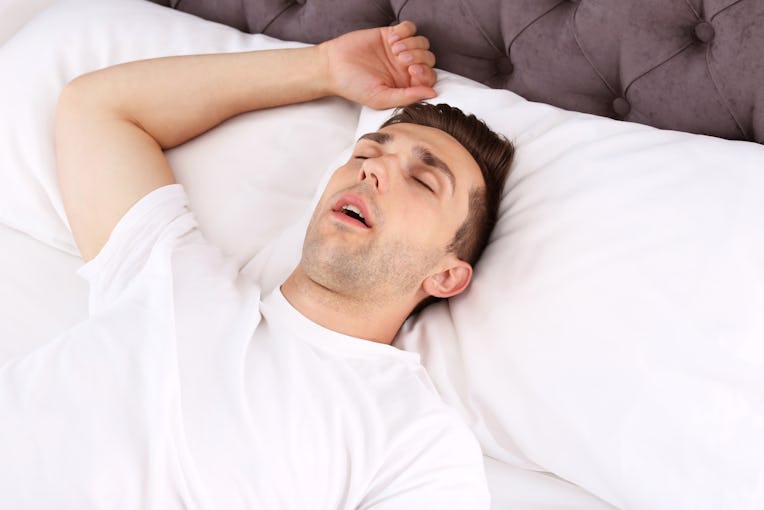 Young man sleeping in bed at home