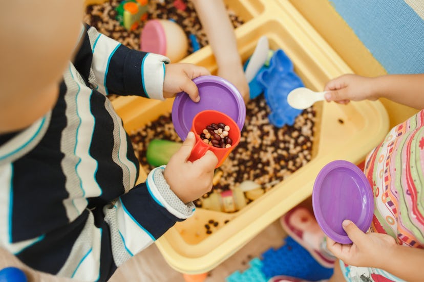 Children play educational games with a sensory bin in kindergarten in a round up of the best occupat...