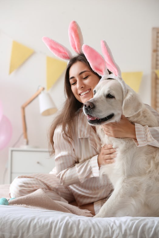 A young woman celebrates Easter with her dog, for which she'll need some bunny puns to use as bunny ...