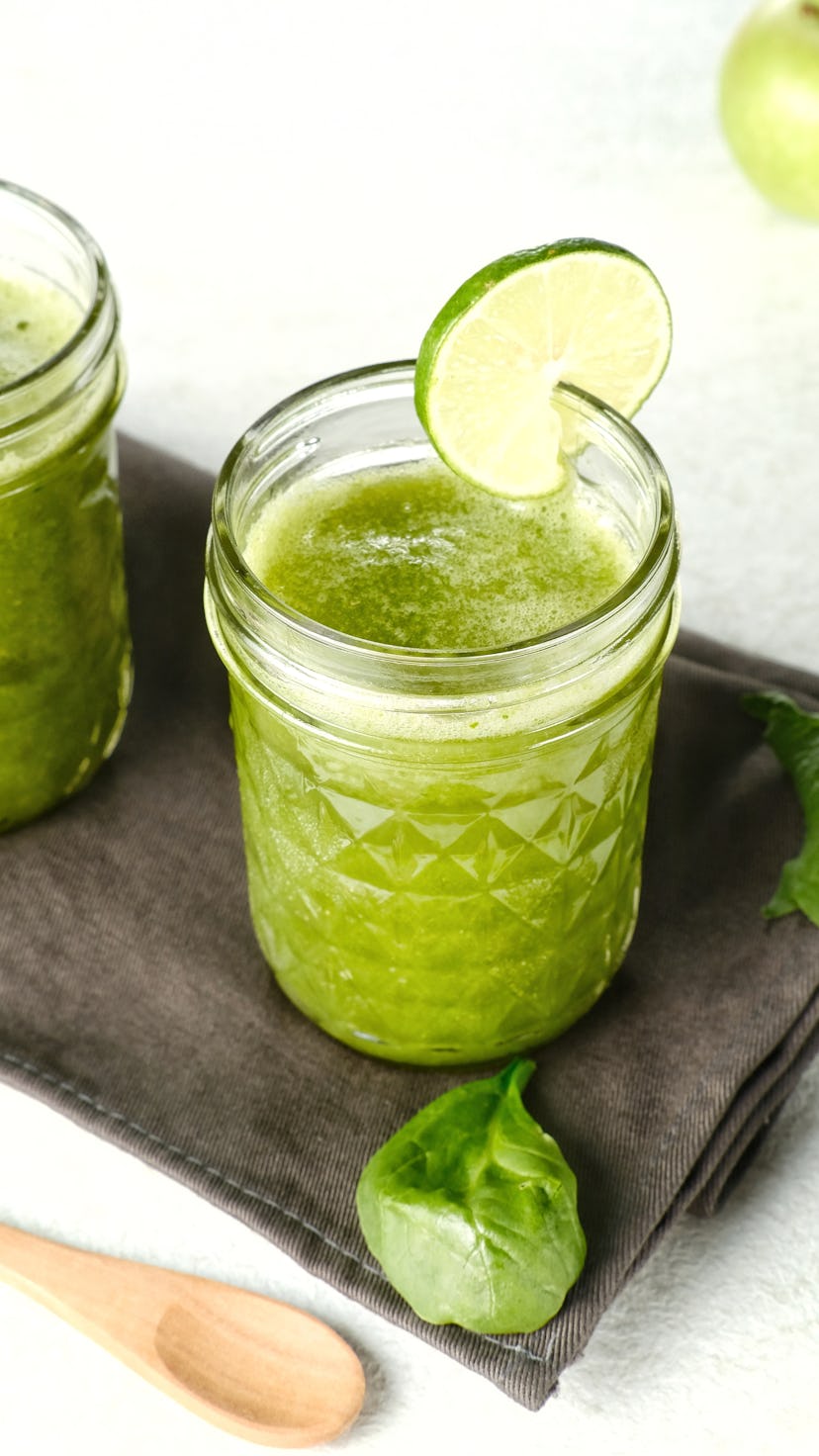 Homemade green smoothie (detailed close up shot; selective focus). Mason jar filled with spinach hor...