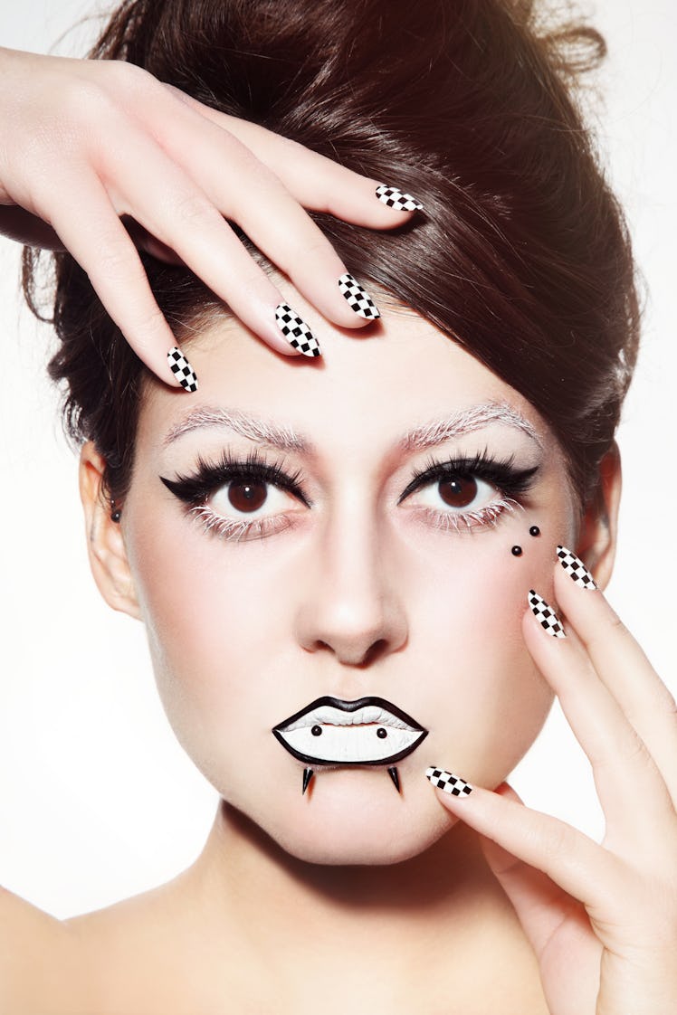 A model with an anti-eyebrow facial piercing and black-and-white makeup.