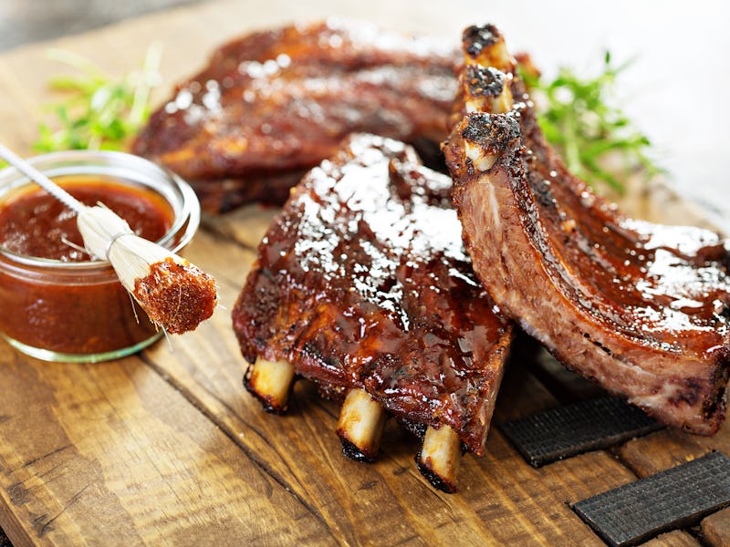 Grilled and smoked ribs with barbeque sauce on a carving board