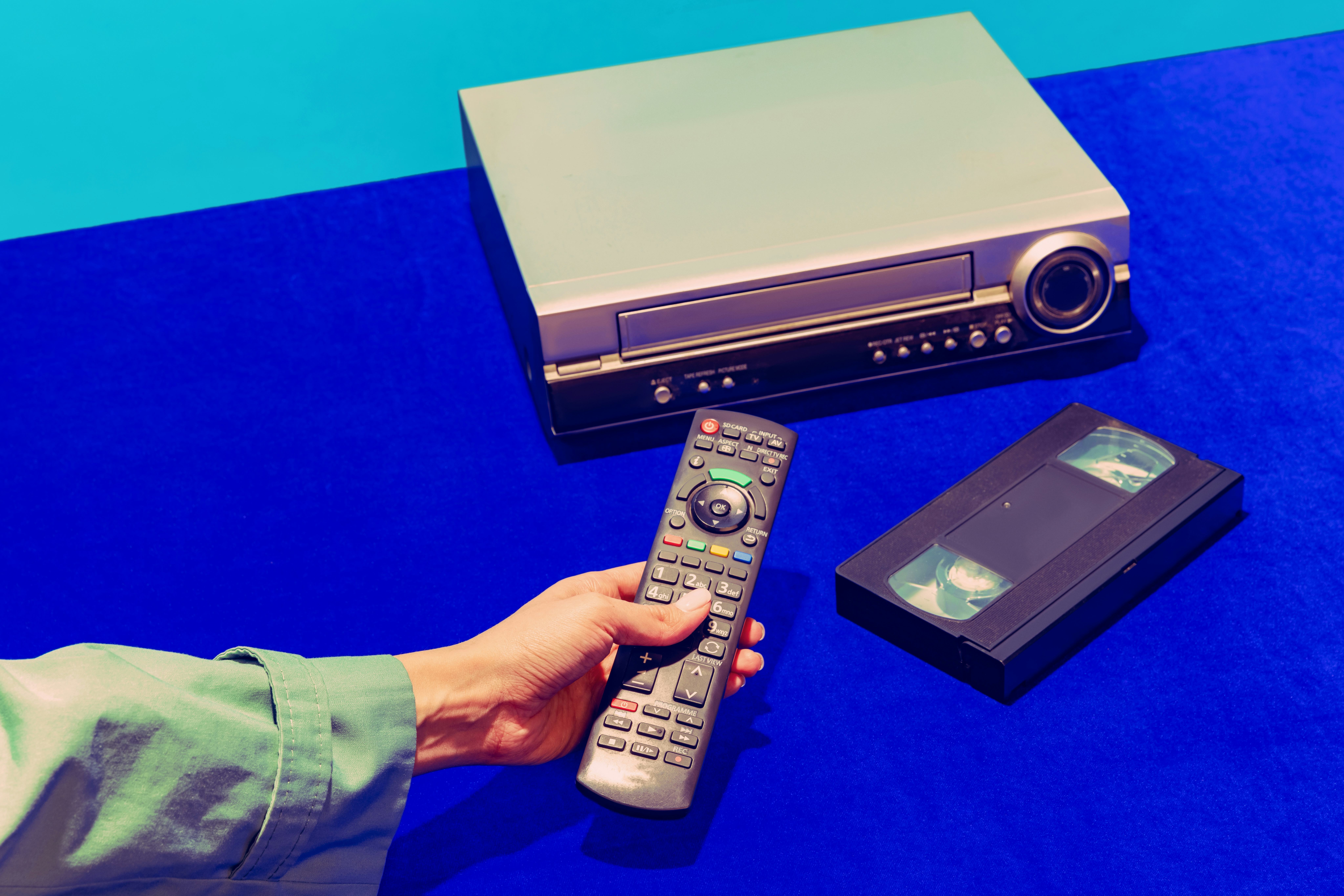 Cinema. Pop art photography. Retro gadgets in modern life. Video recorder and cassette isolated on b...