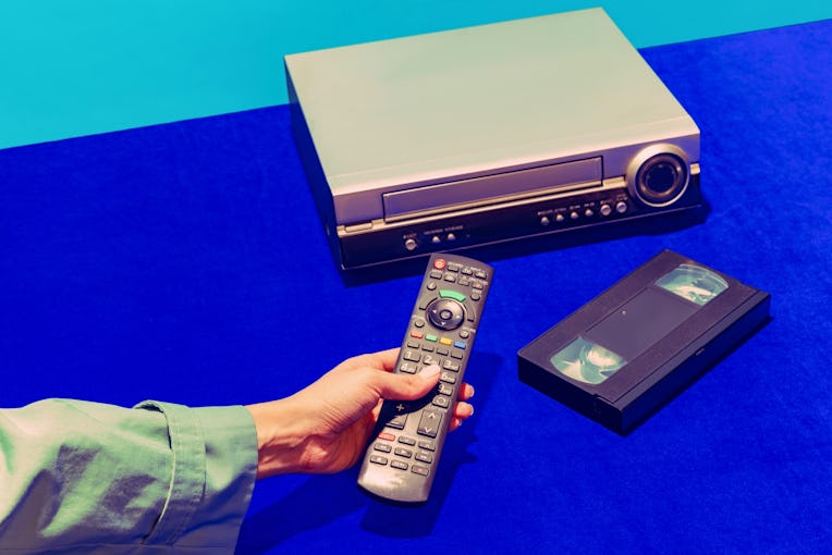 Cinema. Pop art photography. Retro gadgets in modern life. Video recorder and cassette isolated on b...