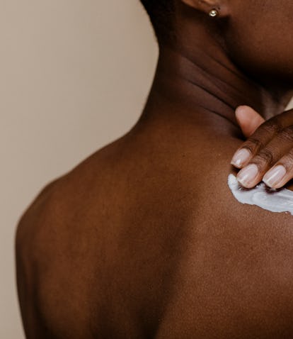 Black woman applying body cream