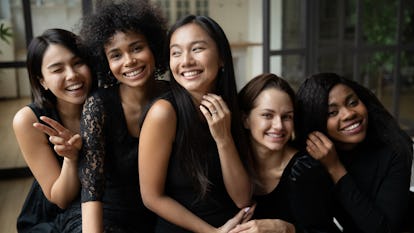 A bride and bridesmaids wearing black wedding dresses, which is a Gen Z wedding trend for 2022, acco...