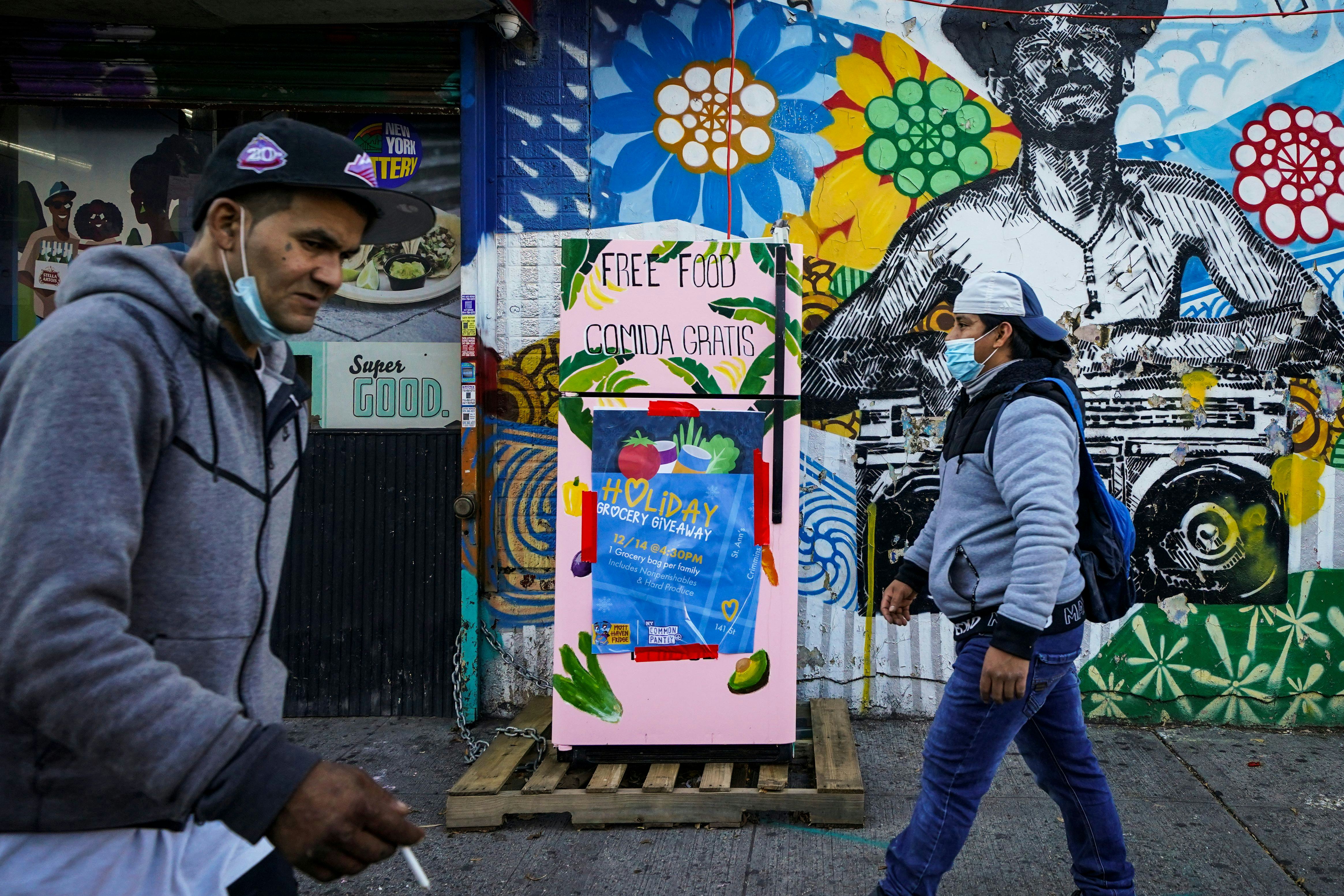 Pedestrians pass a sidewalk refrigerator stocked by various community support organizations to aid t...