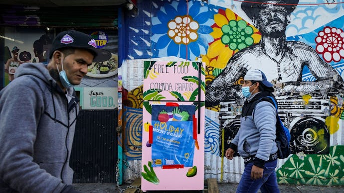 Pedestrians pass a sidewalk refrigerator stocked by various community support organizations to aid t...