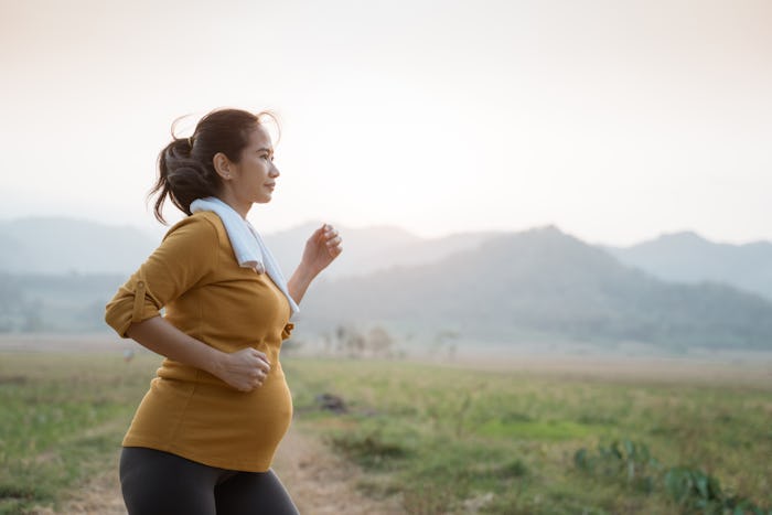 pregnant woman on a run outside in an article about if you can run a marathon while pregnant