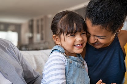 Happy Hispanic mom jokes with her kid at home. Being a mom isn't easy, but the joyful moments help.