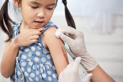 Doctor injecting vaccination in arm of asian little child girl,healthy and medical concept