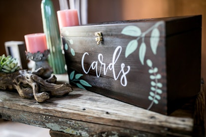 A card box at a wedding reception holds wedding gifts that add up on how much it costs to attend a w...