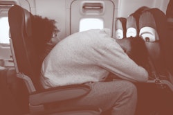 Passengers traveling by plane sleep.