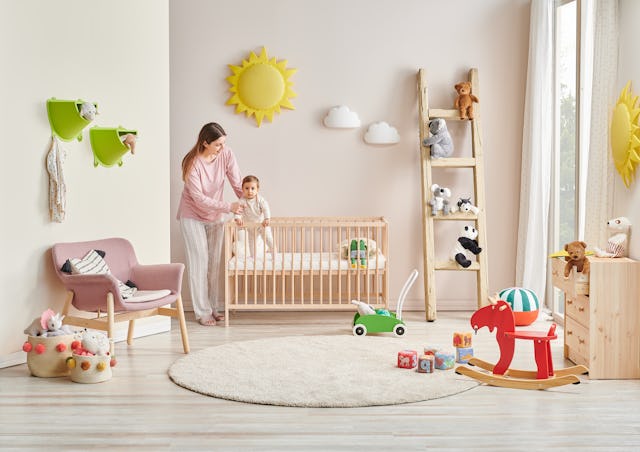 Baby and her mom in the room, decorative interior style with wooden cribbed pink chair toy and stair...