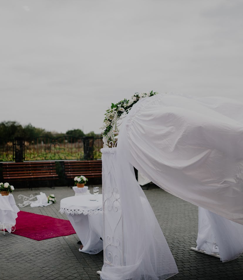 Detail of wedding gazebo on a backyard before or after the wedding ceremony, white wedding arch deco...