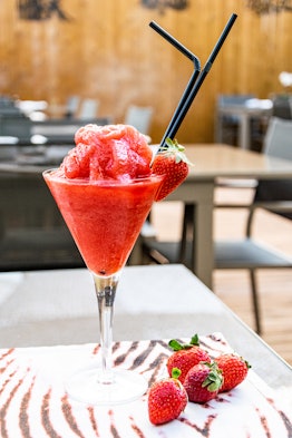 a freshly prepared frozen strawberry daquiri served in a martini glass, which is an easy Memorial Da...