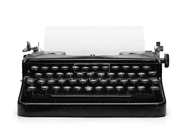 Old vintage typewriter and a blank sheet of paper inserted. Isolated on white background with clippi...