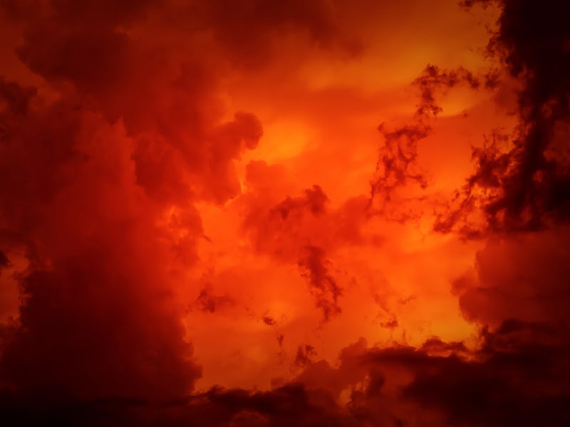 Dramatic red-black orange sky with scary hellish clouds and terrible shadows and light