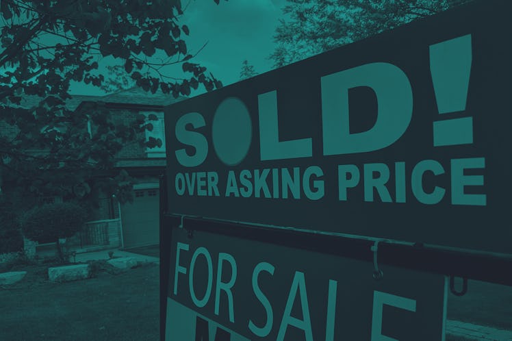 New "sold" sign over asking price for sale in front of house in residential area.