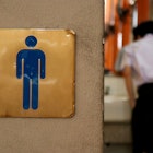 Men toilet sign at school with a boy inside