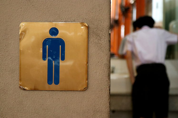 Men toilet sign at school with a boy inside