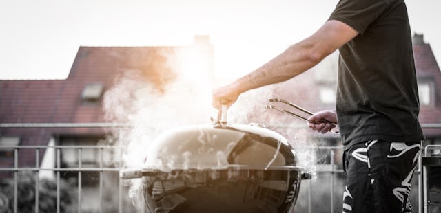 Grill master grilling on the balcony above the rooftops