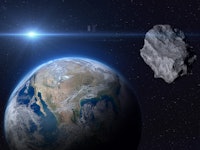 Planet Earth and big asteroid in the space. Potentially hazardous asteroids (PHAs). Asteroid in oute...