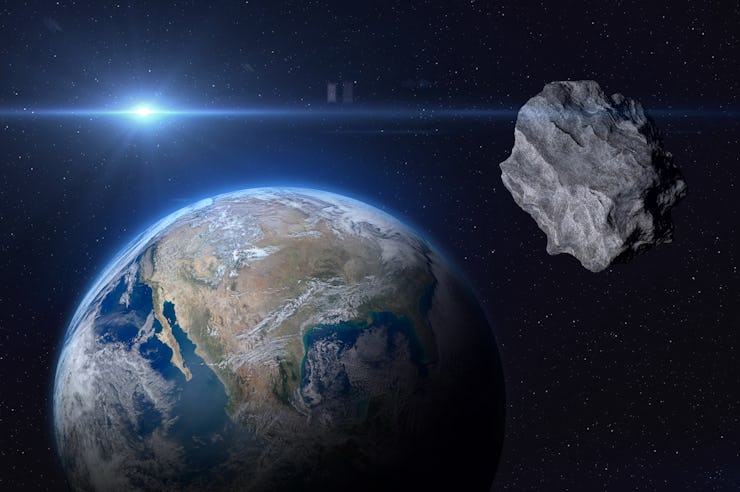 Planet Earth and big asteroid in the space. Potentially hazardous asteroids (PHAs). Asteroid in oute...